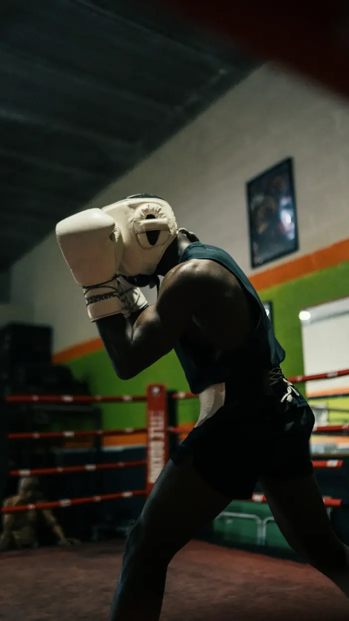 Athl&egrave;te en posture de boxe dans un ring